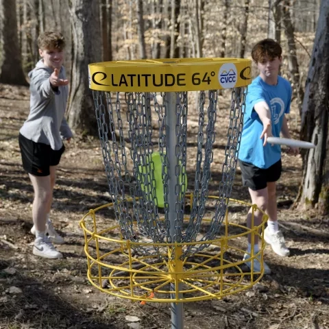 students playing disc golf