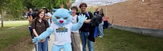 CVCC Ridgecats mascot standing on a sidewalk in front of a group of students