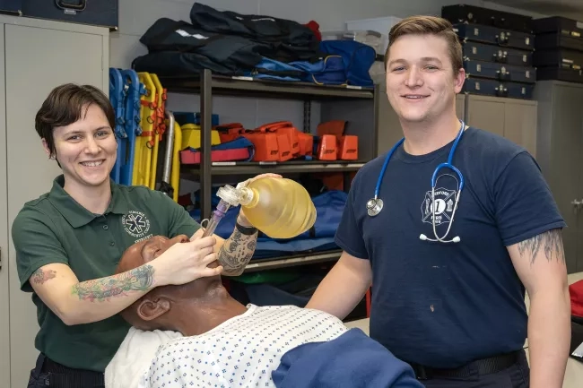 Female and Male EMS students working on manacan