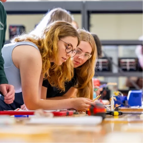 Students leaning over a desk