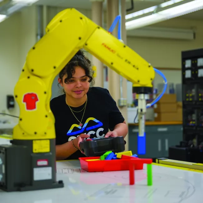 mechatronics students with robot arm
