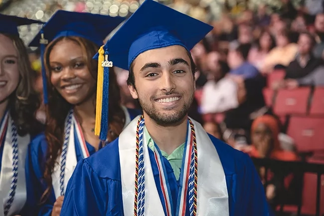 Male student smiling at graduation.