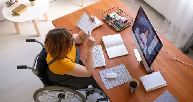 Female student seated in a wheelchair working at a desk