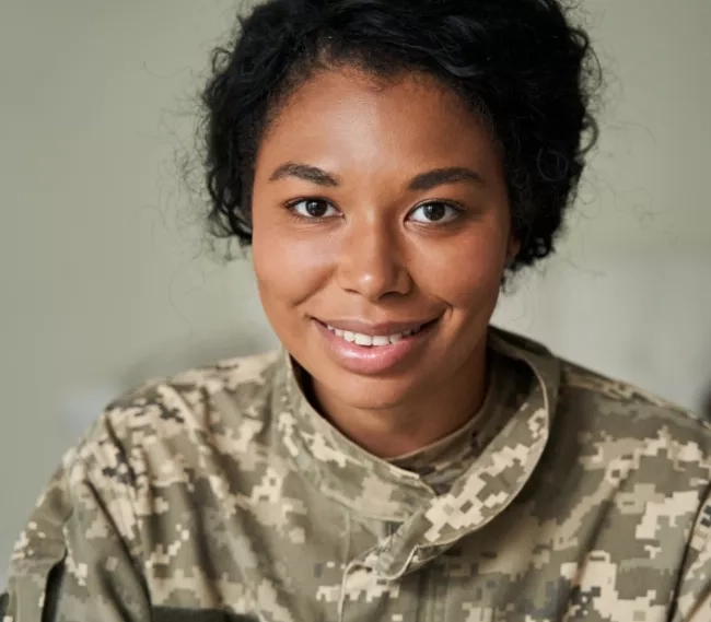 Woman in military fatigues smiling at the camera